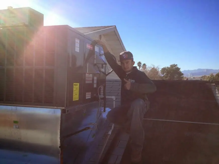 HVAC technician performing Air Duct Cleaning on a rooftop unit in Hopewell